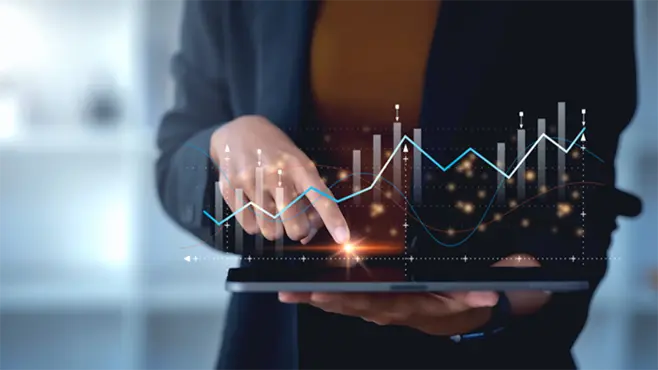 A person using a tablet touches the screen, which displays a graph showing changes in data values.